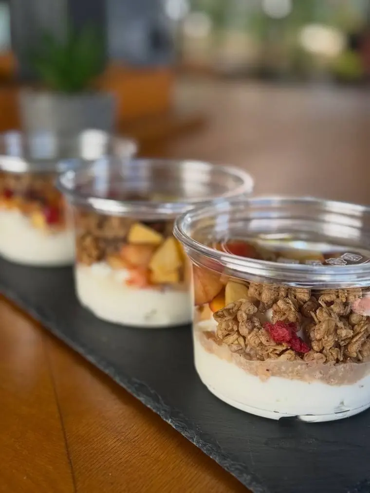 A row of yoghurt and granola pots on the counter