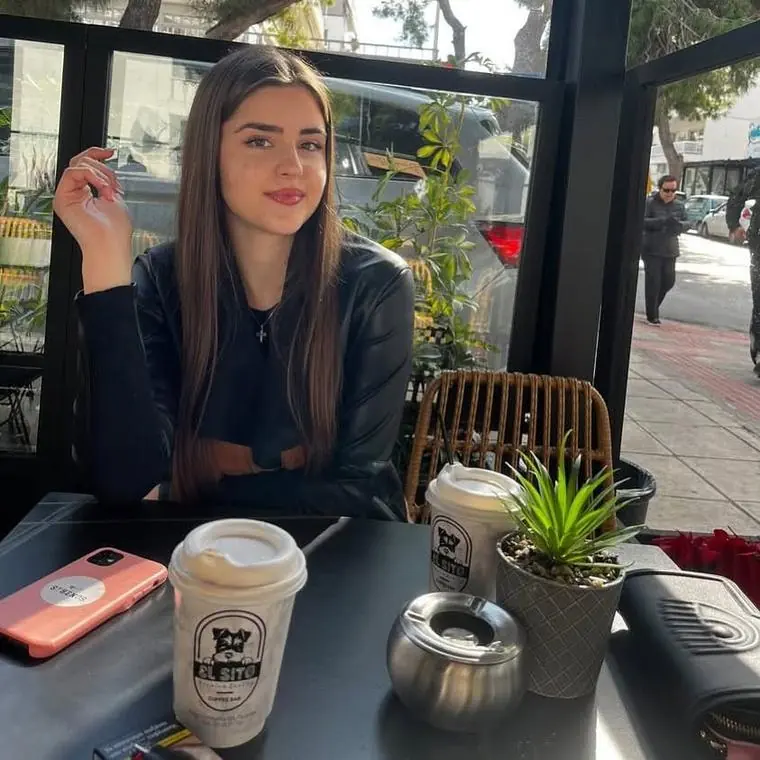A customer at a pavement table with her coffee